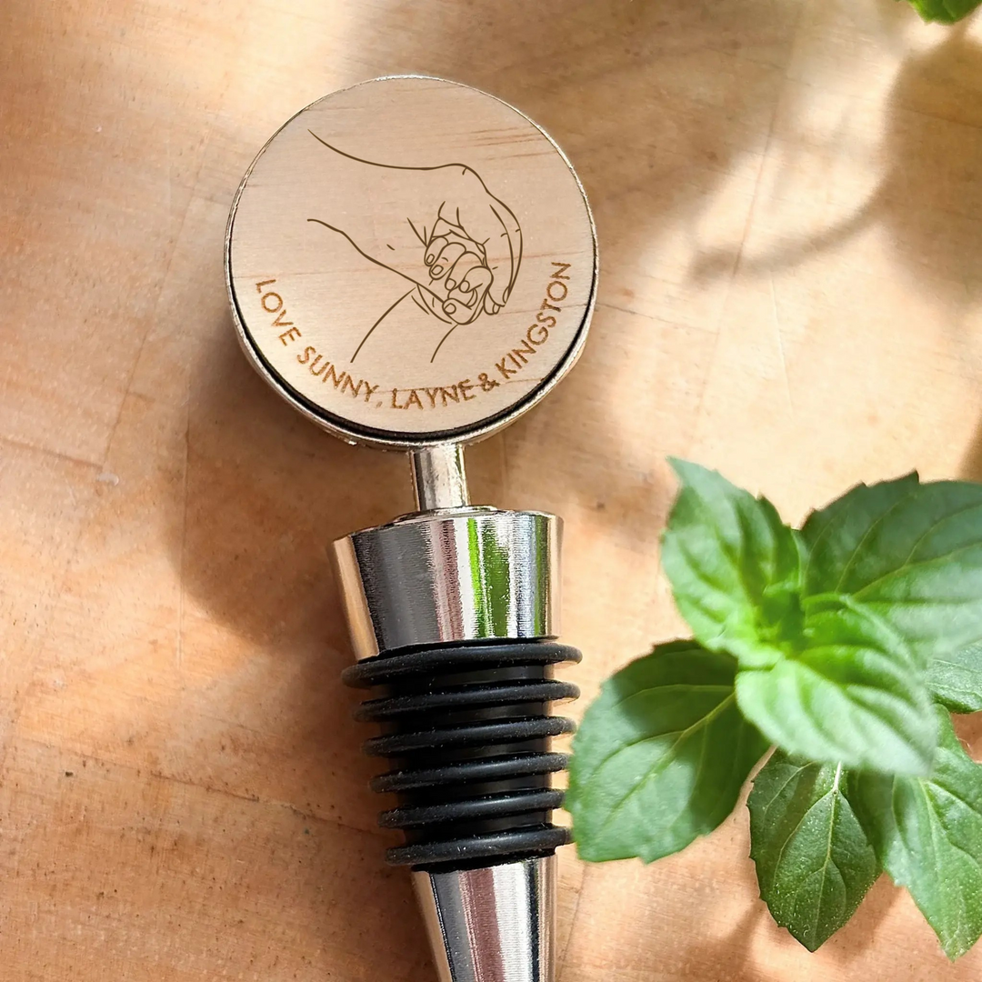 Bottle stopper with engraved design on a wooden surface with leaves